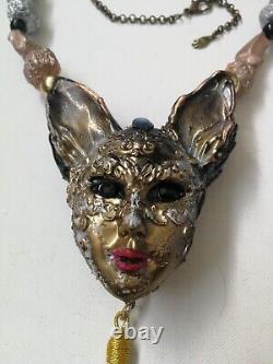 Collier de luxe pour femme en bijouterie, pendentif à l'art déco représentant un chat avec un masque vénitien en or.