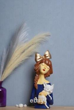 Sculpture en polyrésine fabriquée d'une fille joyeuse avec un chat
